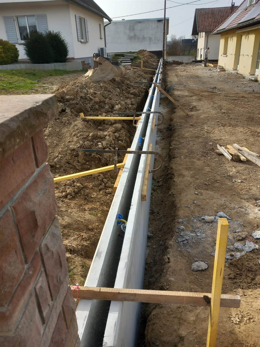 Tranchée de drainage le long d'un muret, terrassement par Kréa Concept dans le Haut-Rhin